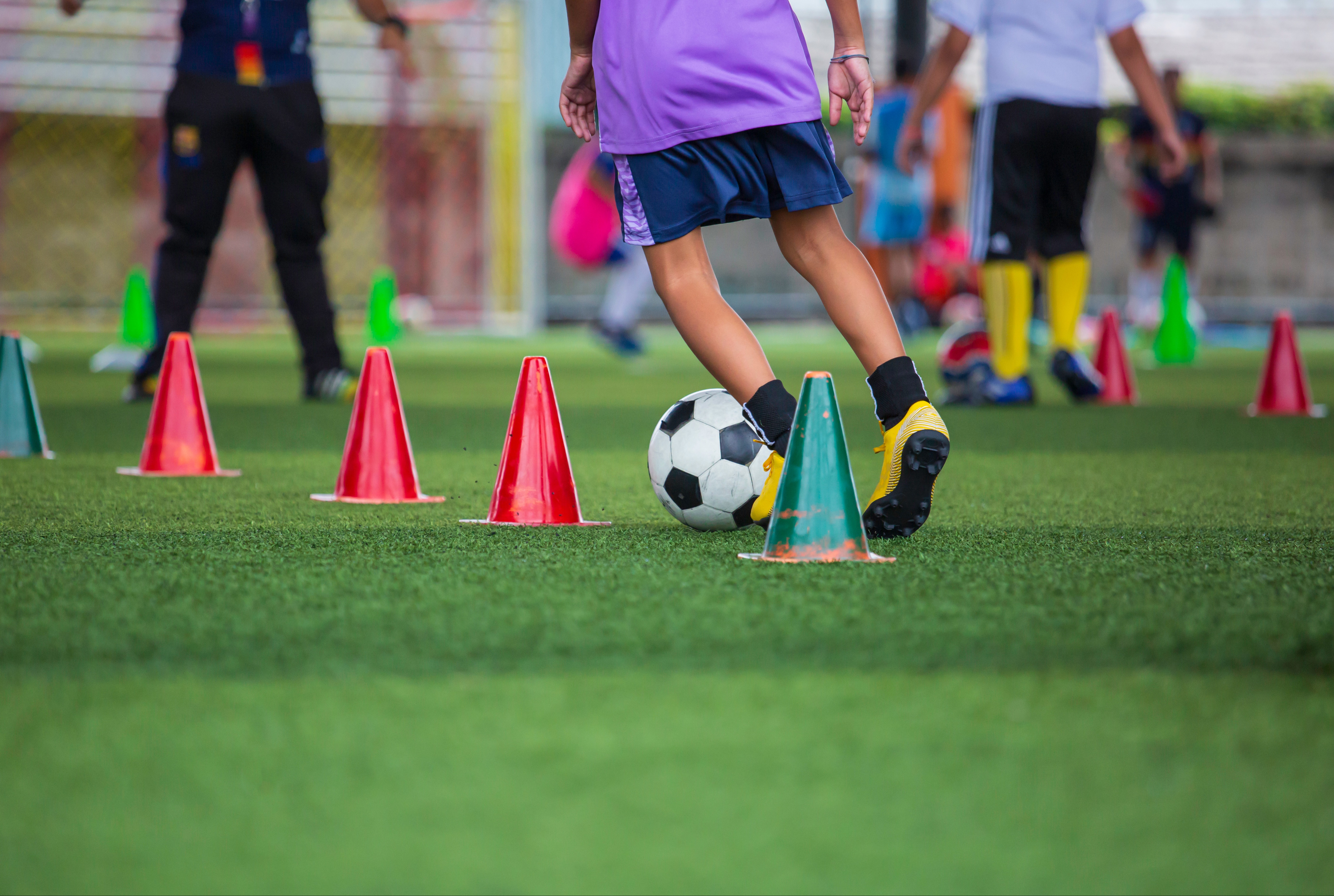 Kinder spielen Kontrolle Fußball Ball Taktik auf Rasenfeld mit für die Ausbildung